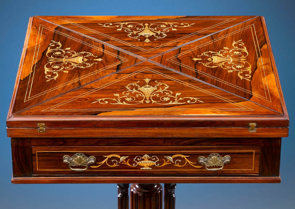 This enchanting English Edwardian envelope table unfolds to become a charming games table. Crafted of fine rosewood and inlaid with classical, engraved satinwood decorations, the table's elegant design incorporates a rotating top with four leaves.