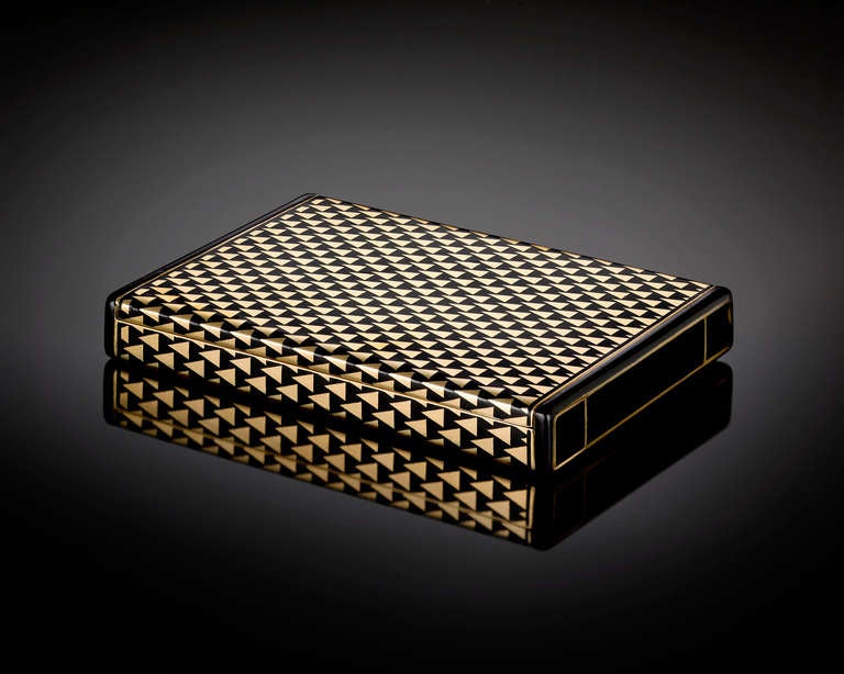 Cartier captures the essence of Art Deco sophistication with this elegant gold box. Crafted entirely of 18-karat yellow gold, this exceptional objet d'art bears a sleek geometric pattern accompanied by contrasting black champlevé enamel on all