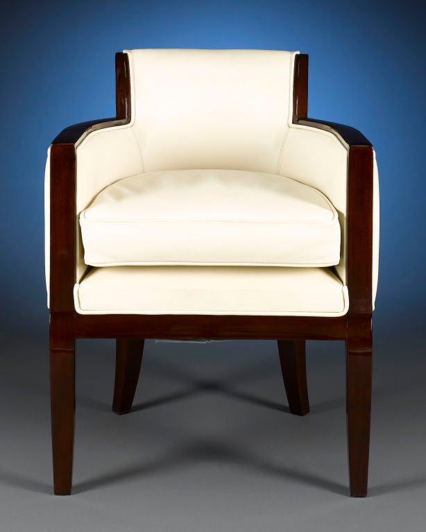 Sleek and sophisticated, this outstanding Art Deco armchair is crafted with modern elegance in mind. White leather upholstery brings an air of luxury and softness to the expertly lacquered wood frame, while the flared back and crescent shape are