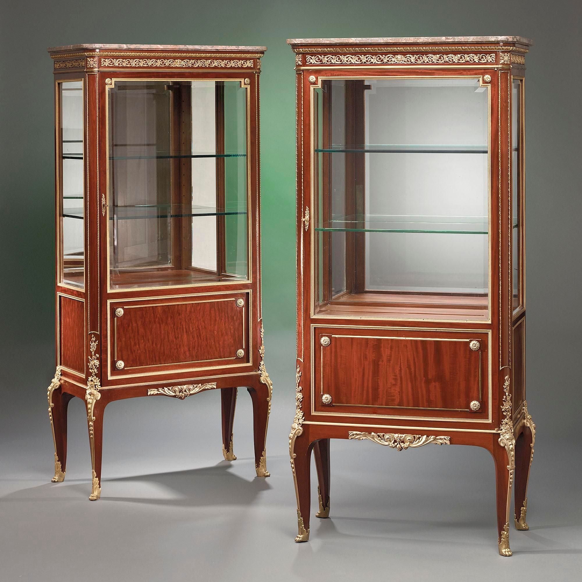 Paul Sormani's superb craftsmanship is most evident in this exquisite pair of mahogany vitrines. Elegantly set upon cabriole legs with paw feet, they are distinguished by flawless doré bronze decoration and an important maker. Sormani, counted among