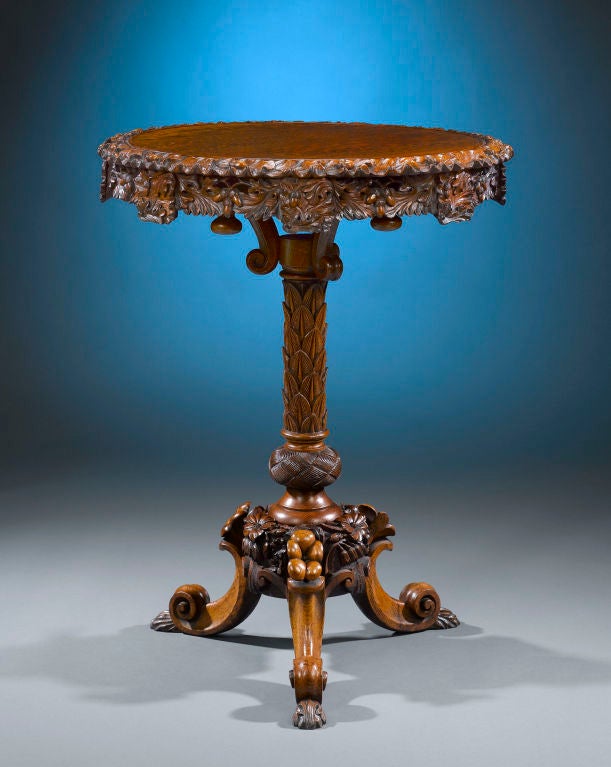 The exquisite, deep carving of this fine oak Lazy Susan occasional table is consistent with the masterful cabinetmaking associated with the famed S.J. Waring firm of Liverpool. Standing upon a tripod base terminating in paw feet, the top of the