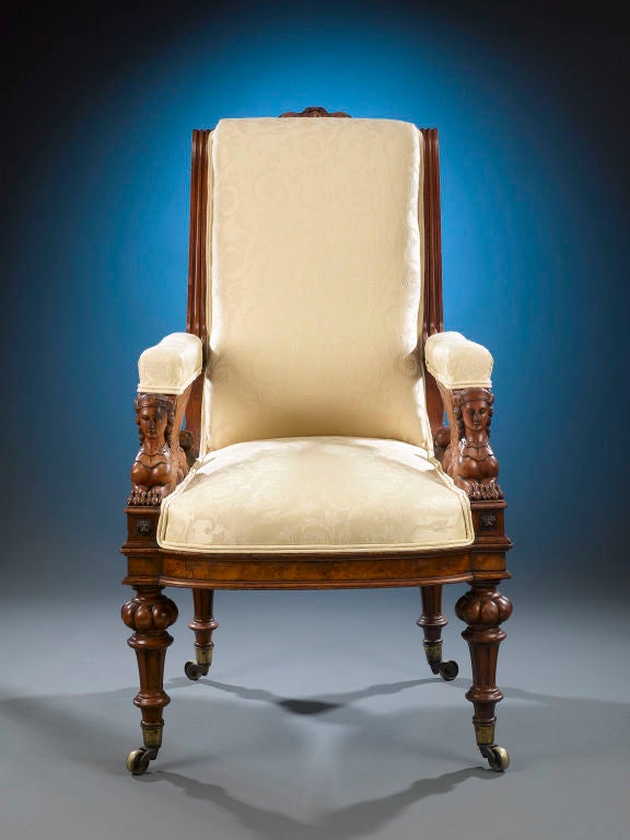 A pair of exceptionally hand-carved sphinxes distinguishes this unique Empire-style armchair. Crafted of handsome, elegantly grained walnut, this chair boasts a high scrolling back, upholstered arms and masterfully turned and carved legs terminating