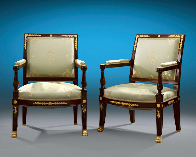 This rare and exceptional pair of bergère armchairs by François Linke exhibits the Empire Revival style. Crafted of sumptuous Cuban mahogany, these stately upholstered seats features baluster rails, padded arms, a bowed seat rail and square back.