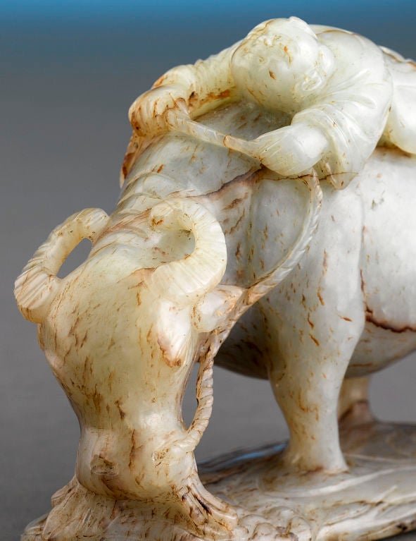 A classic symbol of diligence and patience, this carved white jade buffalo features striations of fei or red jade that has been beautifully incorporated into the form. White jade was mined predominantly in northwest China, and is considered the most