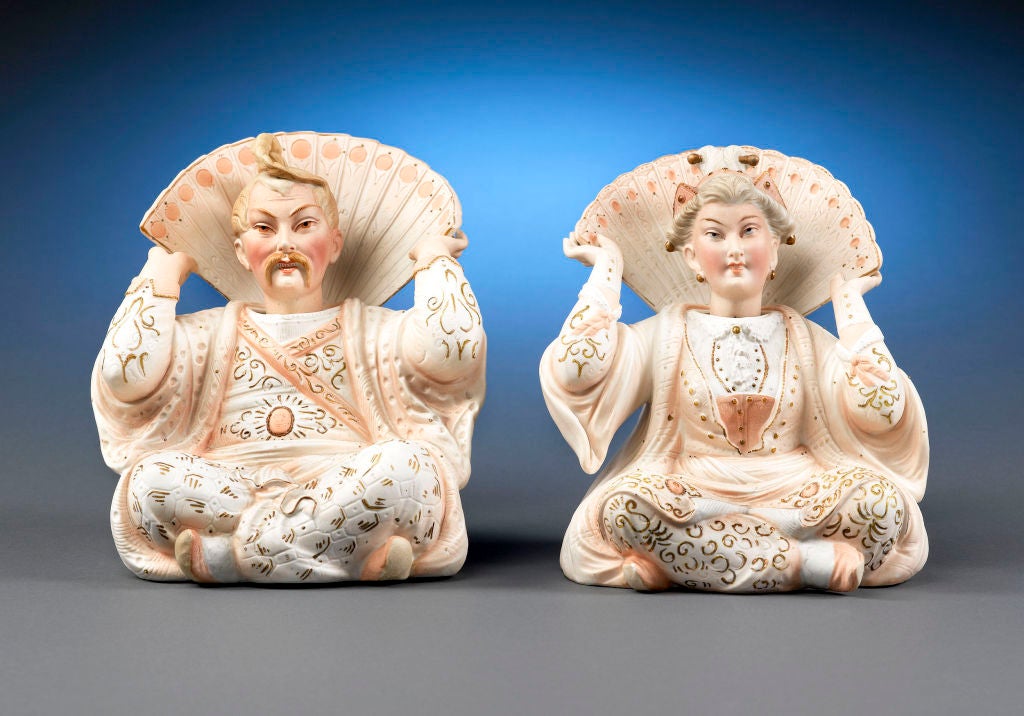 A charming pair of ceramic nodders, depicting an Asian couple in elaborate pastel garments. The modern bobblehead doll, also known as a bobbing head doll, nodder, or wobbler, is directly descended from the German nodders that first appeared in the