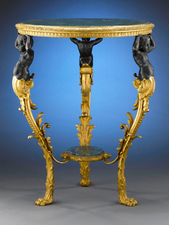 A regal and exceptional antique center table set with a beautiful round Verde Aver marble top and stretcher, created during the reign of Napoleon III. The top is supported by ebonized bronze putti culminating in doré bronze lion paw feet. Verde Aver