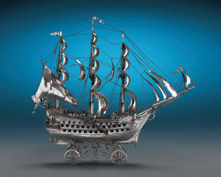 This monumental silver nef by Plateria López is a breathtaking example of Spanish silver. Immense detailing abounds throughout this stunning three-masted vessel which measures four feet in length. From the flying burgees and caryatid figurehead, to