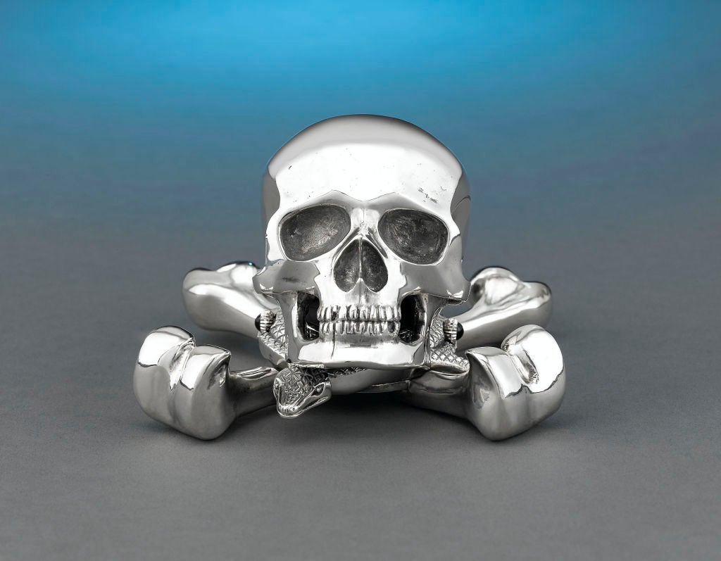 This remarkable Jolly Roger desk clock is one of only 10 such timepieces created by the celebrated Swiss watchmaking firm of Corum. The entire case is crafted of solid sterling silver in the piratic skull and cross-bones, and houses a quartz