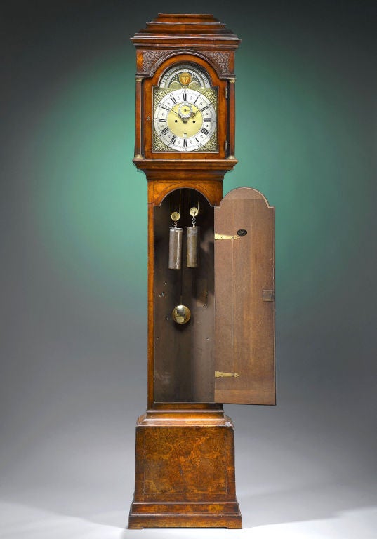 Eine außergewöhnliche Standuhr aus Nussbaumholz des berühmten Londoner Uhrmachers Henry Moze. Das Gehäuse ist von außergewöhnlicher Qualität und wurde aus feinstem Wurzelnussholz gefertigt. Die Formteile am Ende des Gehäuses und die komplizierten