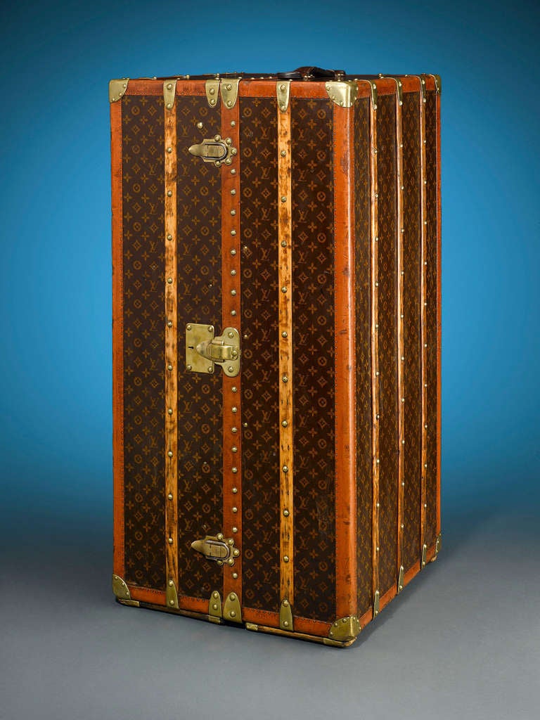 This rare and captivating vintage Louis Vuitton upright wardrobe trunk embodies the elegance and sophistication of a bygone era. Boasting the iconic “LV” monogram on its canvas-upholstered frame, this trunk is fully outfitted to facilitate the most
