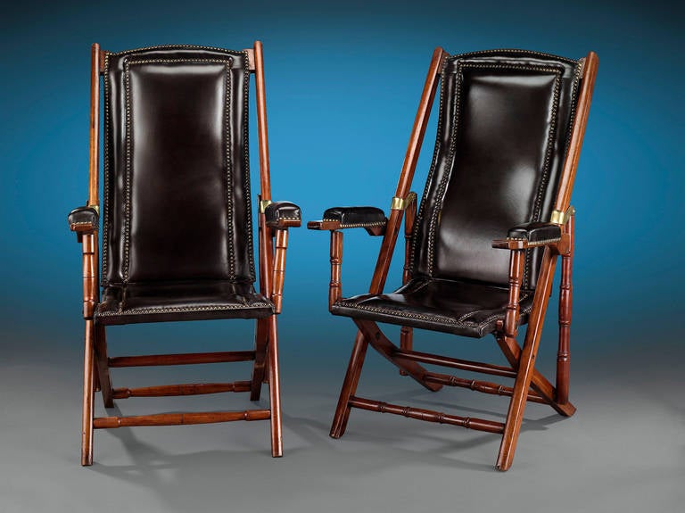 These rare and handsome Campaign chairs would have been used by military officers on the battlefield. The pair is finely crafted of teak with its original tufted leather upholstery, with brass mounts and accents completing their design. The chairs