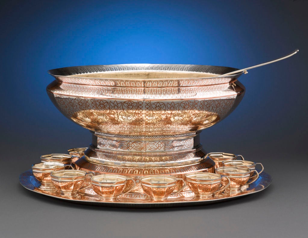 An extremely rare and desirable antique Tiffany Co, sterling silver and copper inlay punch service. Consisting of a generous punch bowl, weighing an incredible 335 ounces, a plateau, twelve cups and a matching ladle, this magnificent service