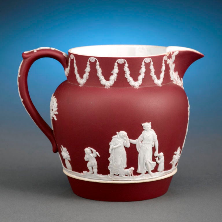 This marvelous Wedgwood jasper dip bas-relief jug displays the rare and highly prized crimson color. Crimson jasper pieces were only created for a short period of time by Wedgwood during the 1920s, and they are highly collectible.  <br />
<br