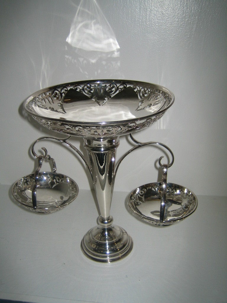LOVELY ENGLISH SILVER PLATED EPERGNE WITH LARGE CENTRAL VASE AND TWO HANGIN BASKETS. THE TOP OF THE EPERGNE AND THE TWO BASKET HAVE BEAUTIFUL CUT OUT DECORATION. A GREAT CENTERPIECE FOR FLOWERS AND FRUIT/CANDY.