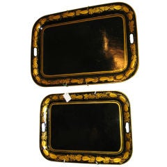 SET OF TWO GRADUATED BLACK LACQUER GILDED TOLE TRAYS