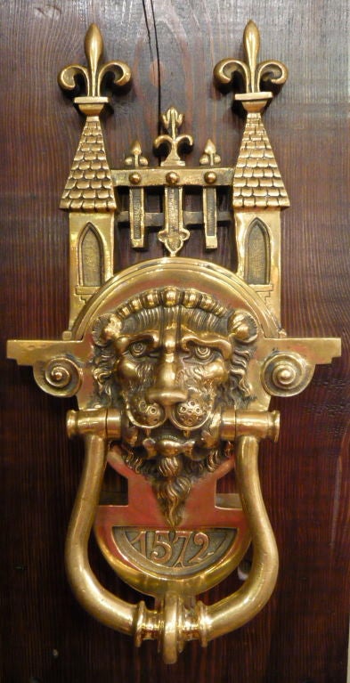A very large English Victorian door knocker of solid brass.  FIne casting, great detail featuring a lion's head, representative of Britain, and crowned with a gothic and fleur-de-lis motif.  An extremely impressive enhancement to any front door. 