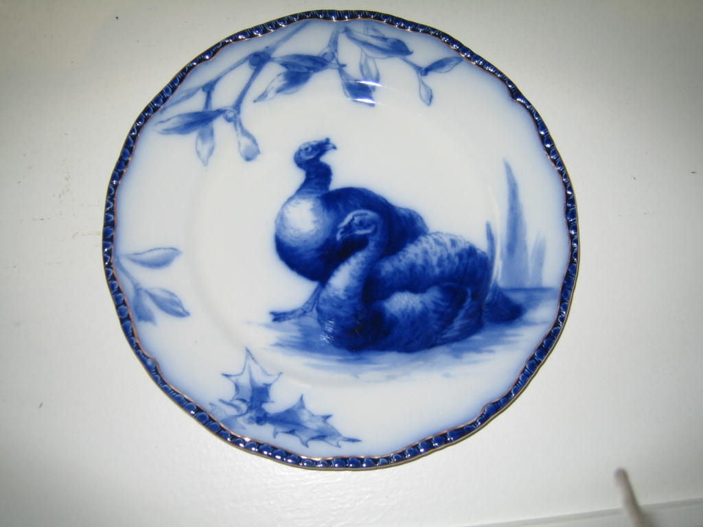 FABUULOUS SET OF HUGE FLOW BLUE TURKEY PLATTER AND 12 DINNER PLATES MADE BY ROYAL DOULTON, ENGLAND. THE PLATES AND PLATTER ARE ALL DECORATED WITH TURKEYS, MISTLETOE AND HOLLY,ALL HAVE GILDING AROUND THE EDGE. ALL PLATES ARE FULLY MARKED ON THE BACK