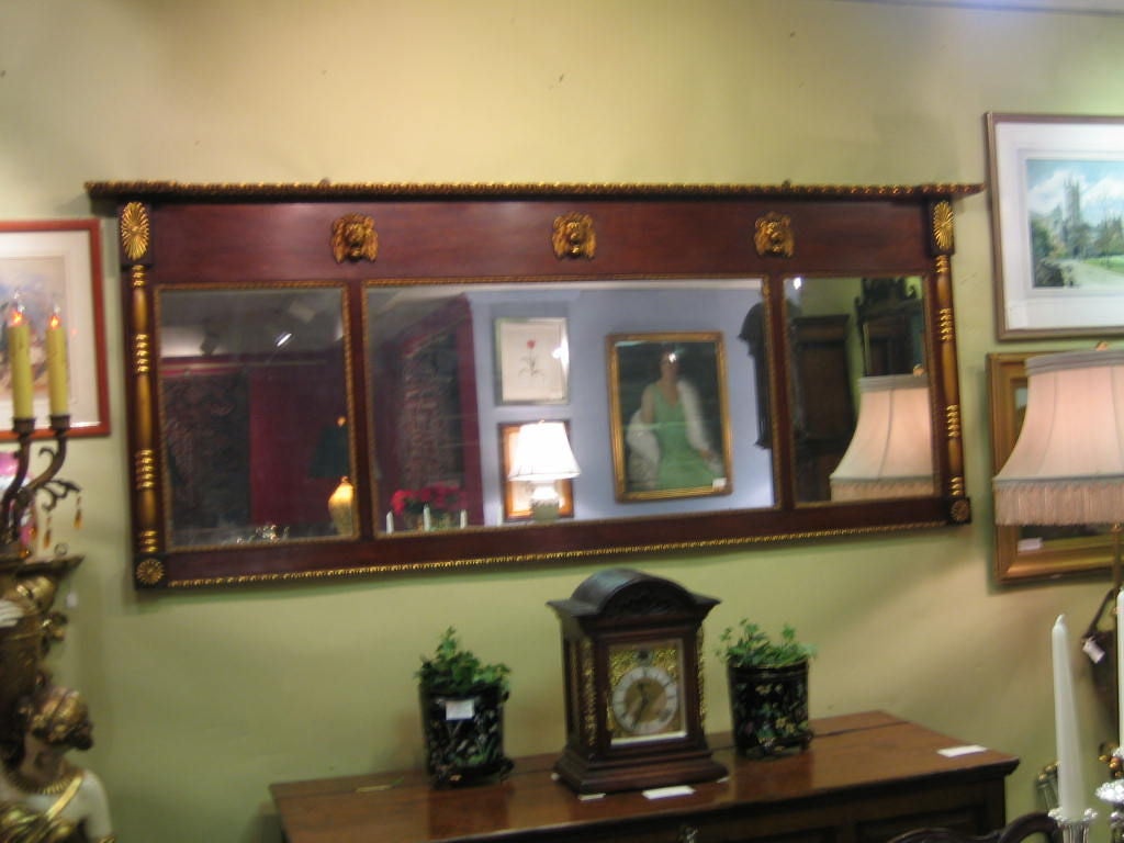 LARGE AMERICAN EMPIRE 3 SECTION MAHOGANY AND GILT OVER MANTLE MIRROR BEAUTIFULLY DECORATED WITH ROARING LION HEADS ACROSS THE TOP, ROPE TWIST AROUND THE EDGES AND COLUMNS ON EITHER END OF THE MIRROR. THIS STILL HAS THE ORIGINAL MIRROR, WHICH