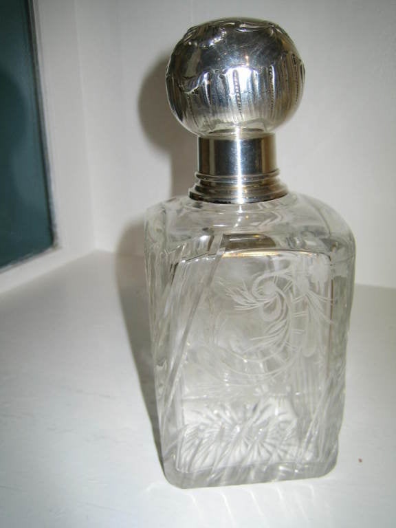 LOVELY FRENCH CRYSTAL AND SILVER TOP BOTTLE WITH SMALL GLASS STOPPER INSIDE THE LARGER TOP. THE GLASS IS BEAUTIFULLY ETCHED WITH A FLORAL DESIGN . THIS IS A PIECE OF HIGH QUALITY.