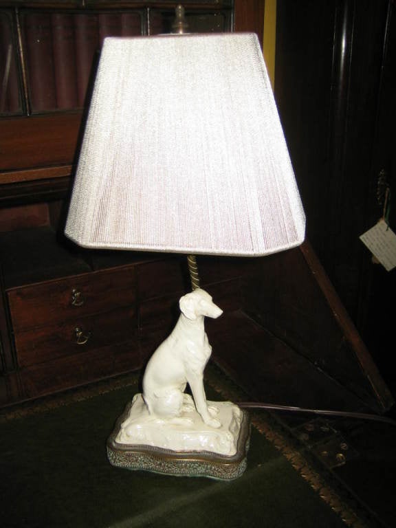 LOVELY FRENCH FAIENCE WHITE CERAMIC DOG LAMP ON BRONZED BASE WITH NEW STRING SHADE. MEASUREMENTS TO TOP OF SHADE. DOG HEIGHT IS 9 X 5.5 X3.75. A GREAT SMALL LAMP TO ACCENT WITH.