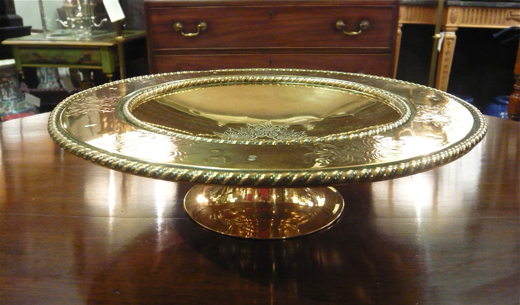 A lovely English brass footed tazza featuring a twisted rope design along both the inner and outer edges of the broad rim as well as etched decoration around the rim and a central etched medallion.  Overall measurements are noted below.  Additional