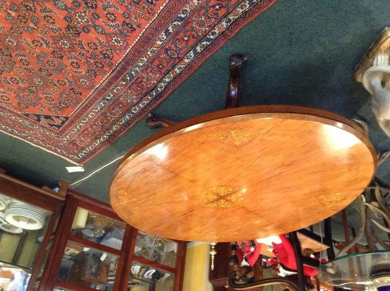 Beautiful English Victorian burr walnut oval loo table inlaid with satinwood on exquisitely hand carved legs. The table still has it's original castors and has been cut down from the original 30 inch height to 20 inches to be used as a coffee table.