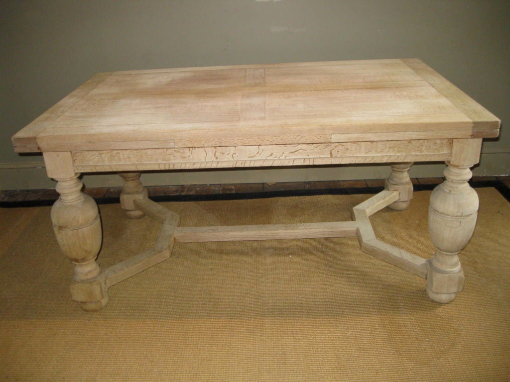 This oak dining table has been bleached to its new patina. The table has classic jacobean style finial legs.  When extended to its full size, the table measures 105