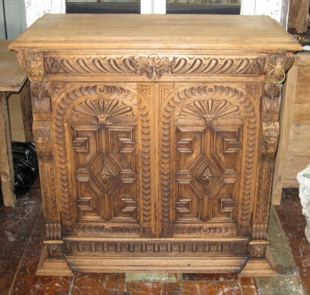 Bleached oak buffet from the Mechels District of Belgium. There is a center top hidden drawer. The double doors below open to reveal  2 storage shelves.<br />
The intricate design is hand carved. Note the lion heads on either side of the top drawer.