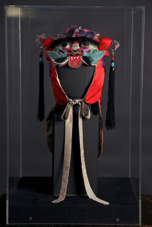 Embroidered silk headdress, circa 1960's-1970's. Fine example of Asian detail and design, with brightly colored accents. Note the particular detail of the tassels, silk eyes and sash. It is contained within a plexi-glass display case, and can be