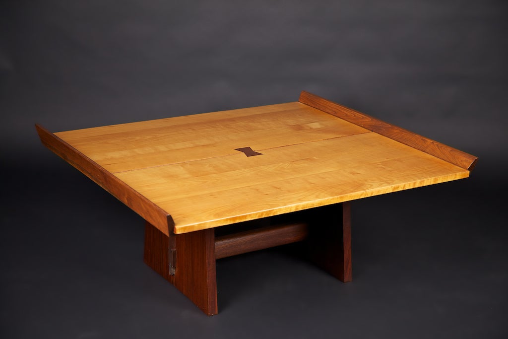 This is one of the earliest George Nakashima coffee table designs, originally created in the milk house of the Raymond Farm in the 1940's. The edge pieces on this table serve to stabilize the wood as well as provide a striking 'winged' design