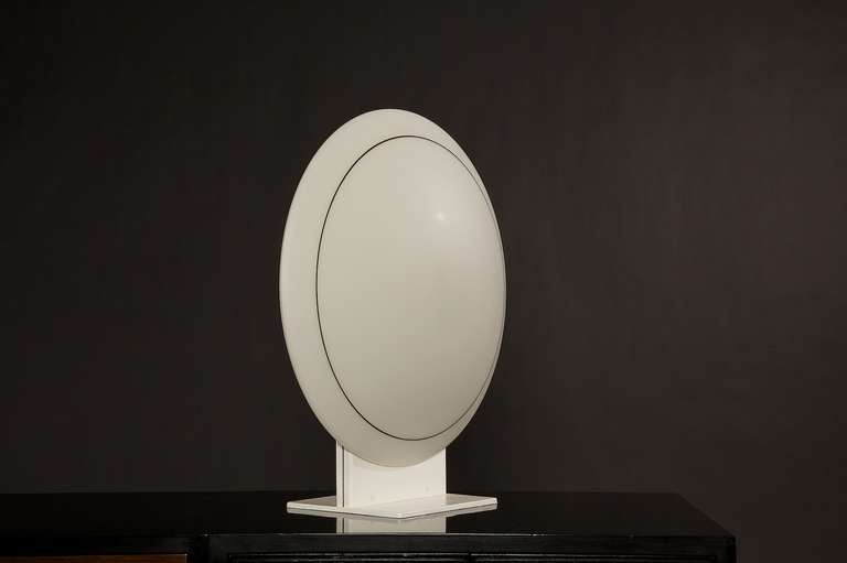 You are view a Minimalist Roche Bobois table lamp from Paris. A striking piece from any angle. When lit in a room it gives off a beautiful light without it being intrusive. It is a large piece, 21.5 inches in diameter. The shade sits on a powder