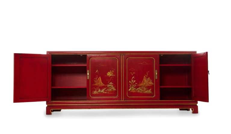 This Asian-inspired Credenza by John Widdicomb can also be used as a buffet or sideboard, a cabinet or even as a dresser. There are four doors and four interior shelves. The deep red lacquer, and hand-painted Asian scenes make it a striking piece