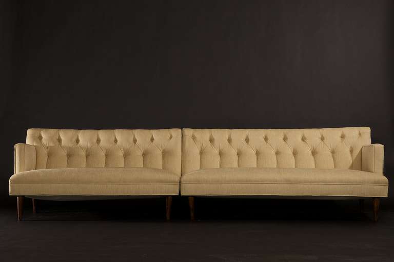 A gorgeous sexy two-piece set of circa 1960s tufted sofas. The sofas have a firm seat and backrest. We love the strong arm profile of these sofas. They are expertly finished in expensive light cream upholstery in excellent condition. They can both