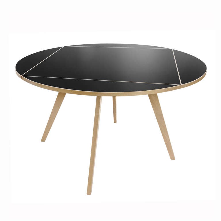 The square-round table by Max Bill was originally designed in 1949. It features an innovative and easy-to-use lock mechanism to expand the tabletop from square to round. The table is beautifully crafted using solid maple, clear lacquer, and black