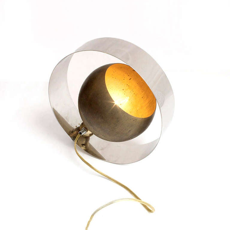 This unique lamp features an antique brass fixture, and a stainless steel sheet rolled in a perfect circle around the brass.	

RM Fischer's distinguished style in his earlier career is elegantly utilizing metals like brass, aluminum, and bronze.