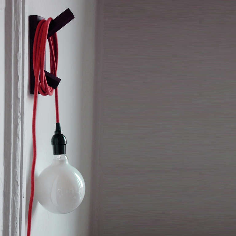 Trouble Light by Sam Stewart is a wonderfully straightforward, playful fixture that features a cotton cloth cord available in five colors and either a white oak or black walnut mount. Paired with a softly-lit, spherical 25-watt bulb, trouble light