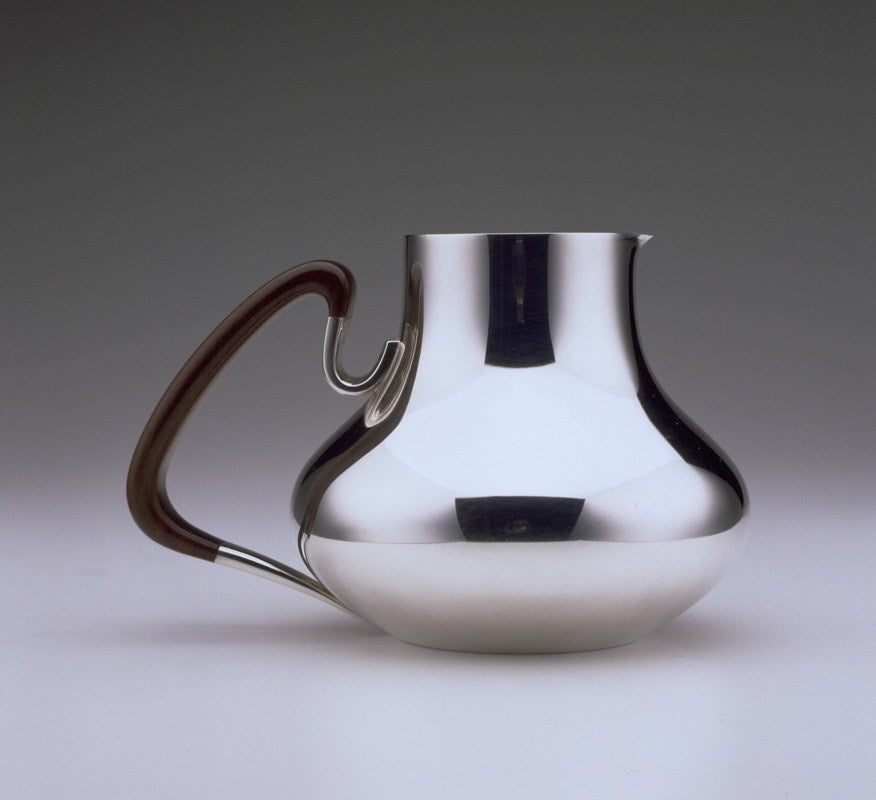 This Pitcher designed by Henning Koppel in 1952. Squat and circular, Koppel's holloware is distinguished by its sculptural quality. In Koppel's lifetime he received many international awards including the Lunning prize in 1953.