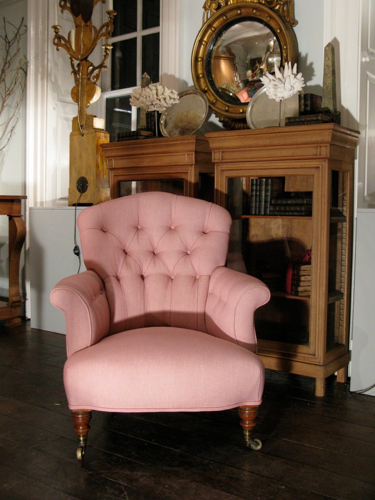 A very good quality, and comfortable, late 19th century English armchair, by the well known makers Howard & Sons Ltd. The Country House chair, retaining the original stamped brass castors, has just been reupholstered in a pink linen, and will make a