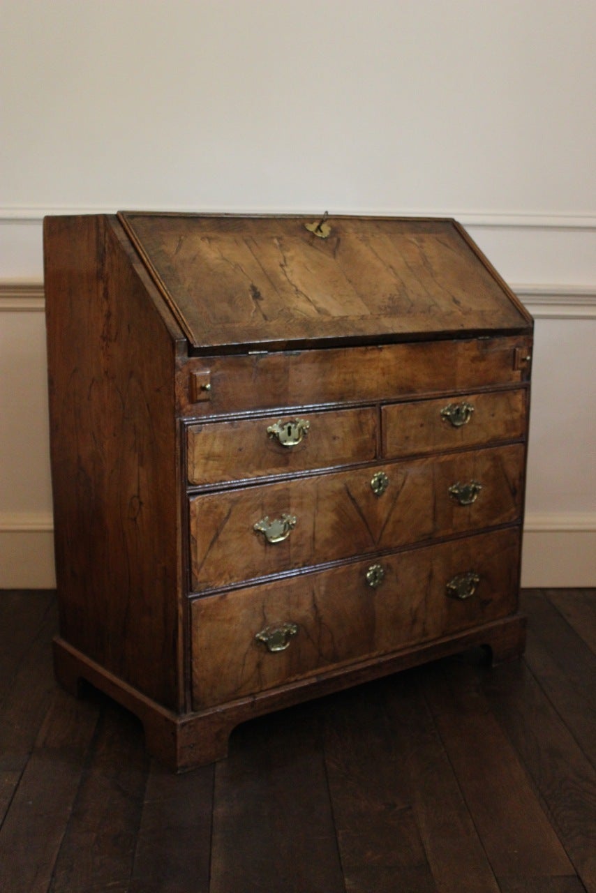 A good quality and with a lovely color, early 18th century English walnut bureau, with feather banded fall-front enclosing a fitted interior above two short and two long drawers.