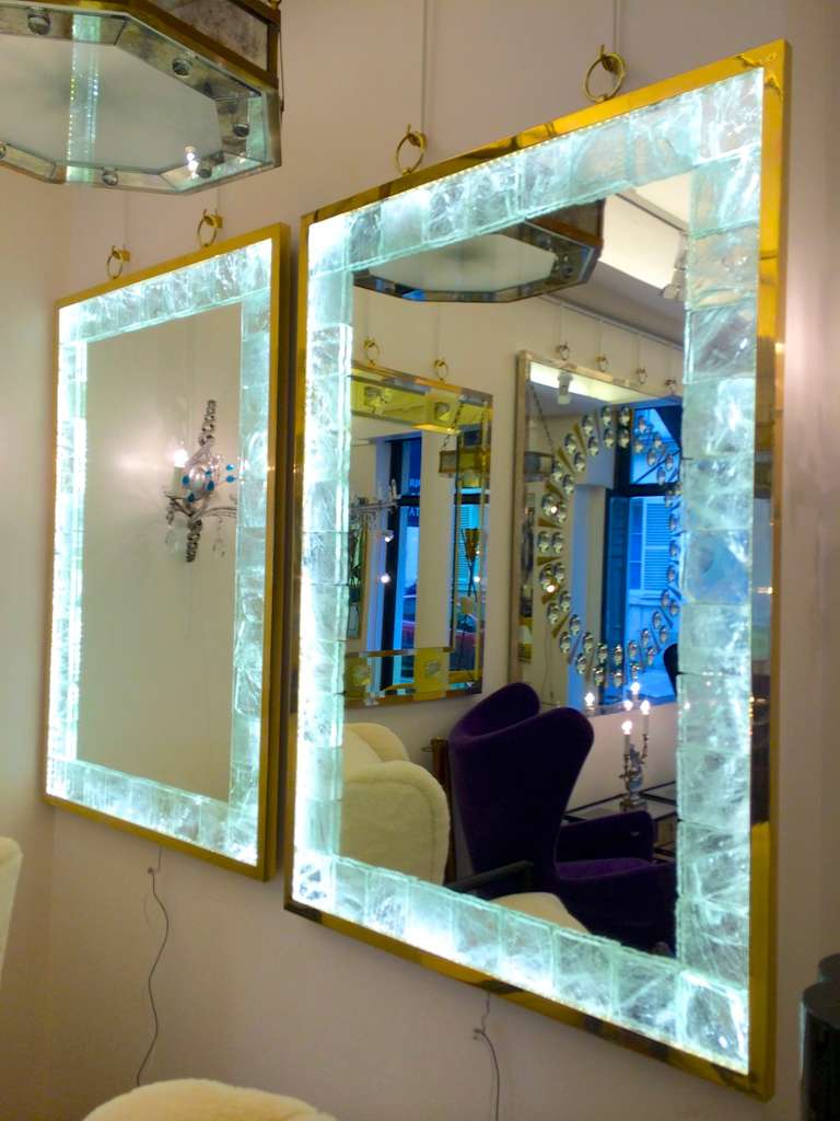 André Hayat pair of lighted etched rock crystal mirrors with gold bronze frame and hanging rings.
