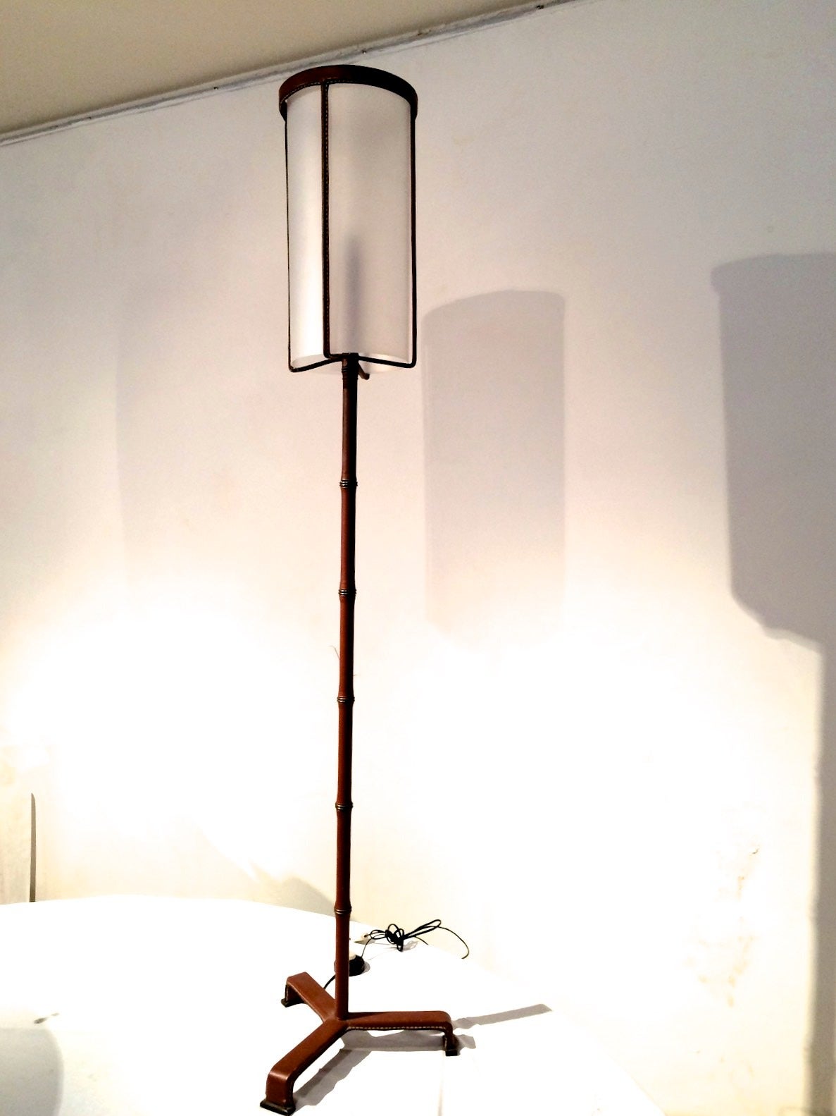 Jacques Adnet rarest brown hand-stitched leather tripod standing lamp.