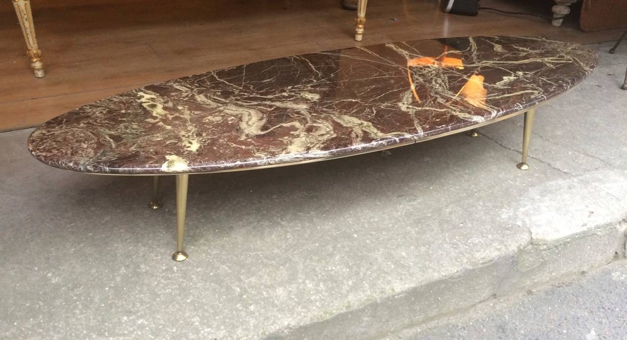 Italian superb long oval surfboard look slender coffee table with a marble top,
And brass base.