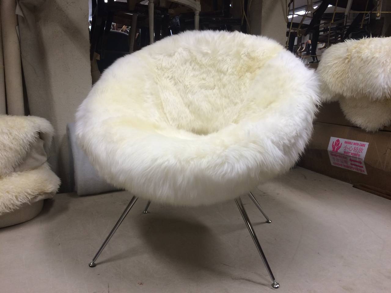 Flying saucer style pair of chair covered in genuine long haired sheep skin fur.