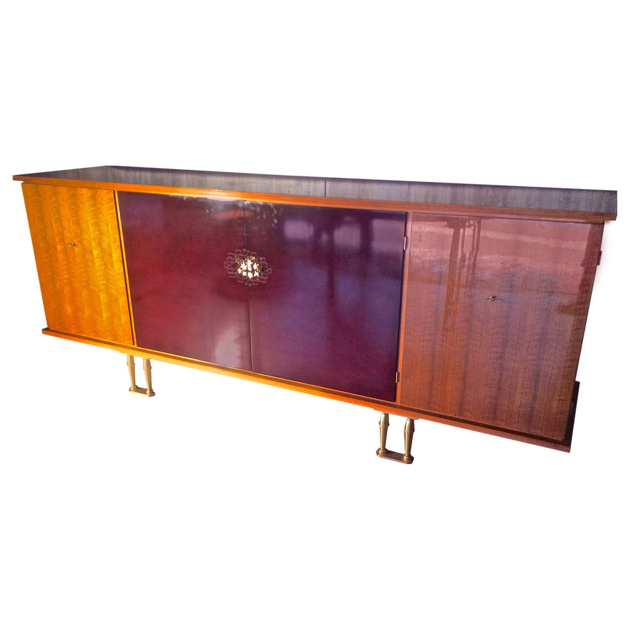 Jules Leleu documented 1950s four doors with red lacquer by Sain et Tambute
with sycamore inside including a bar and a full drawers for cutlery.
We offer a matching extendable round dining table with leaves on our site.