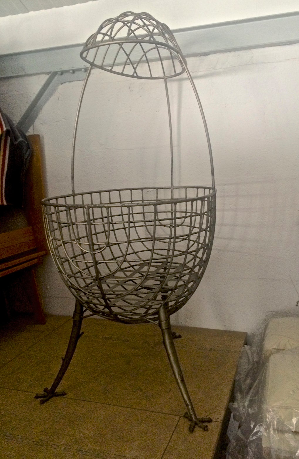 Awesome egg shaped cradle in sculptured wrought iron with chicken legs.