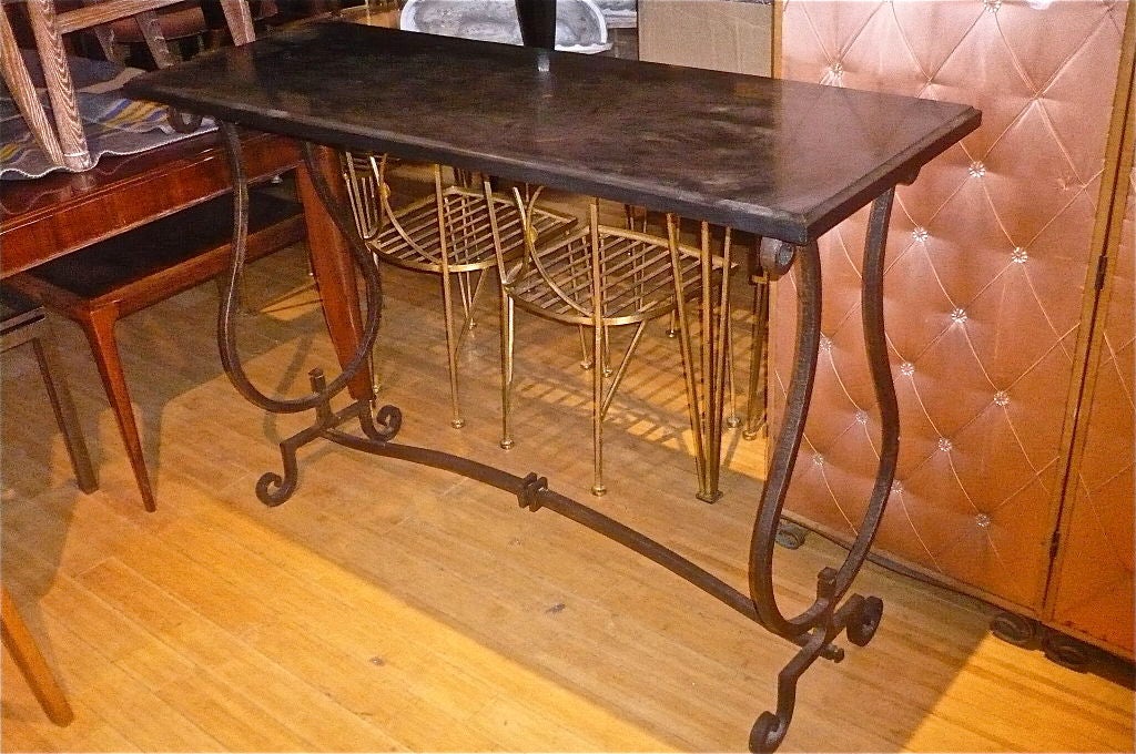 Elegant narrow and long console by Gilbert Poillerat with a harp side design

in wrought iron and black marble top.