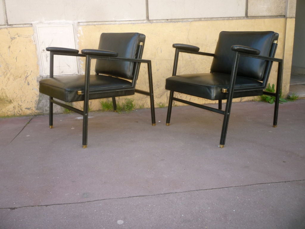 Jacques Adnet chic pair of black hand stitched lounge chairs with solid square brass end.
