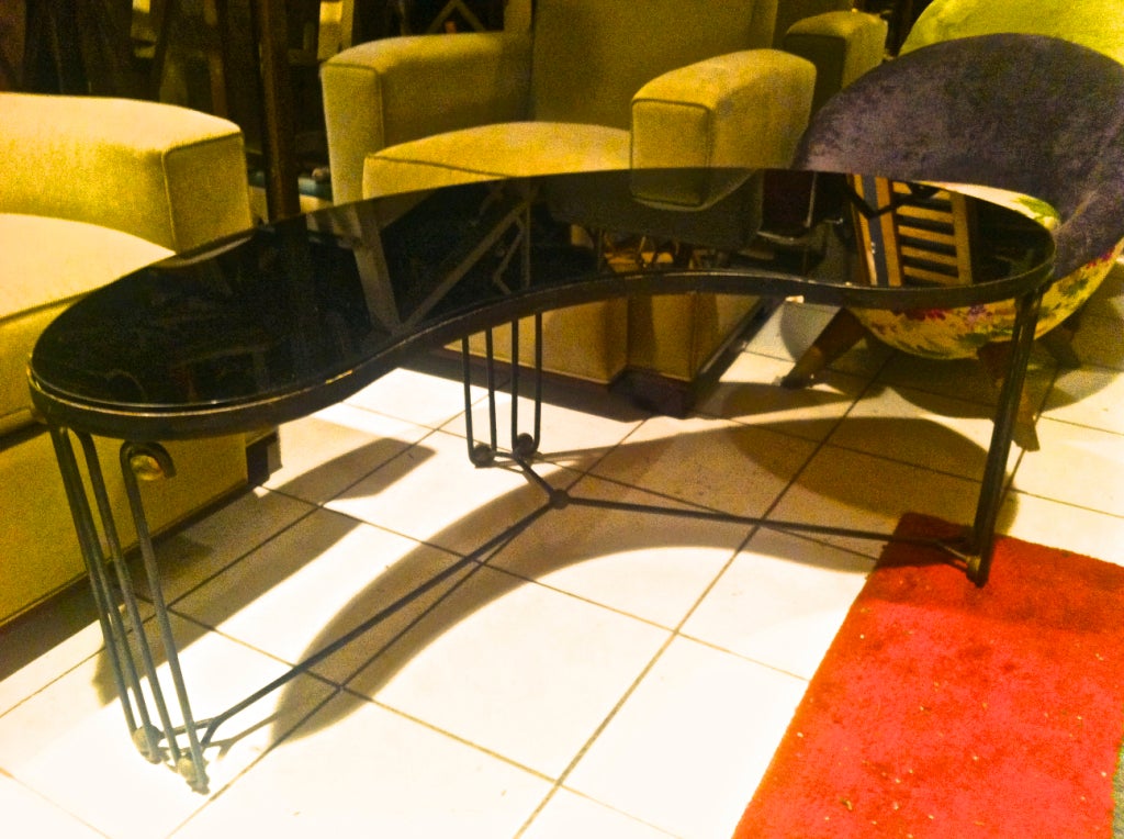 Jean Royère rare boomerang coffee table in black wrought iron with wave leg and brass balls.