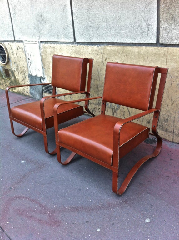 Hand-stitched brown leather pair of lounge chairs by Jacques Adnet.