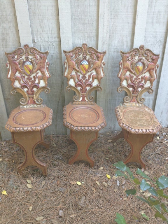 Three Scottish Baronial hall chairs with carved and painted armorial backs.